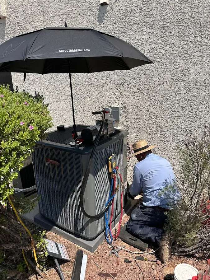 HVAC technician performing outdoor AC maintenance in Red Bank
